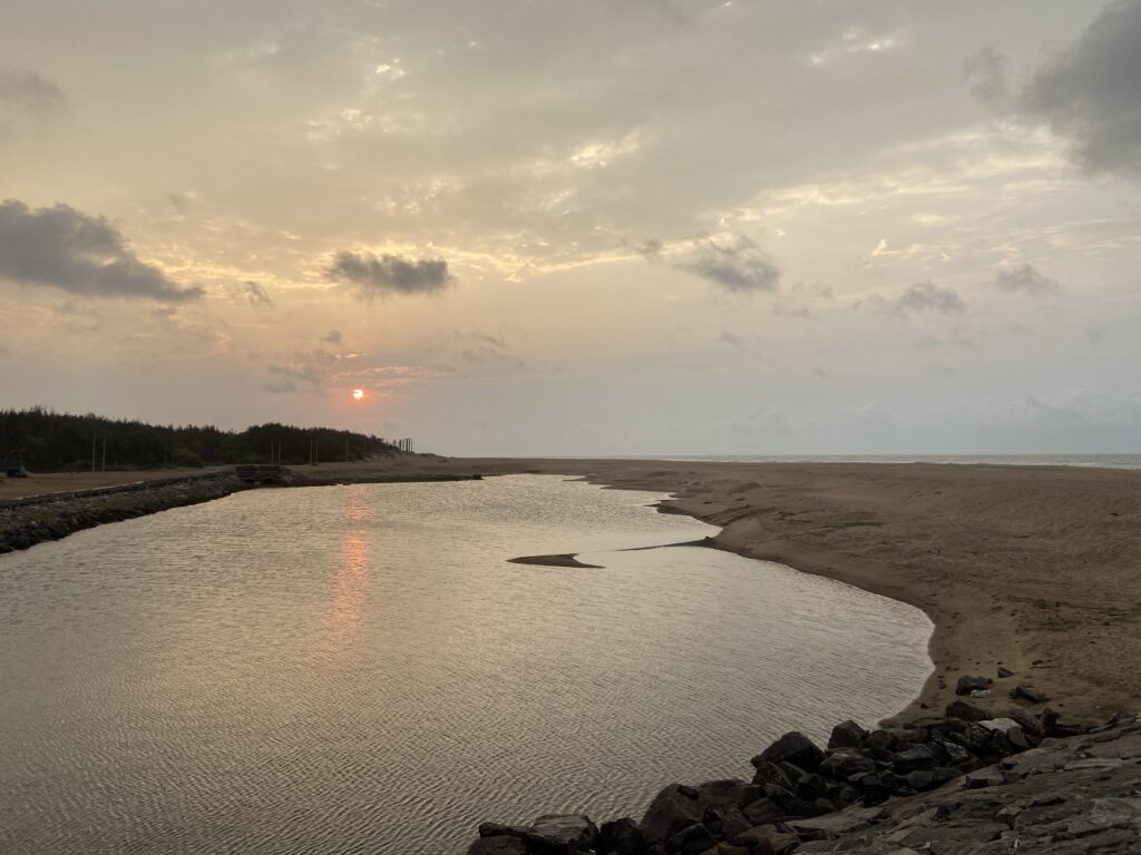 Sun rising over land, reflection on a small area of backwater